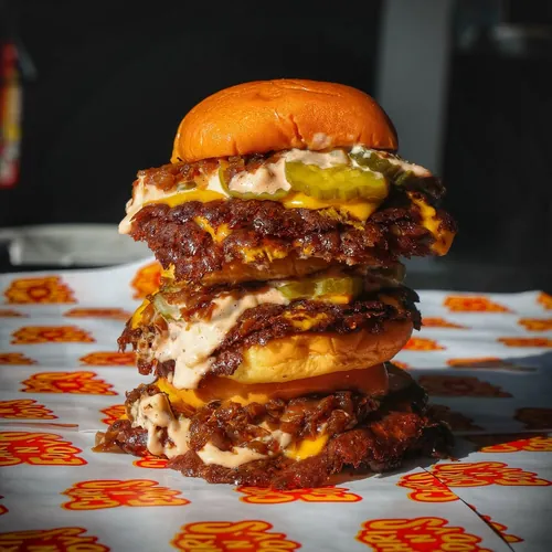 A towering Chris N Eddy’s smash burger with pickles and sauce